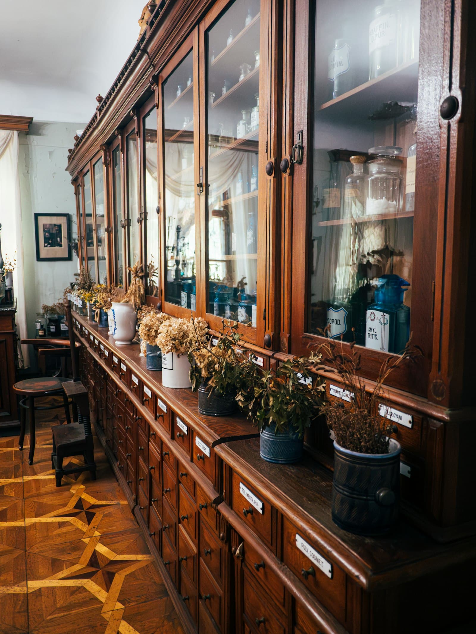 Antiker Holzschrank mit Glasgefäßen in warmer Raumstimmung